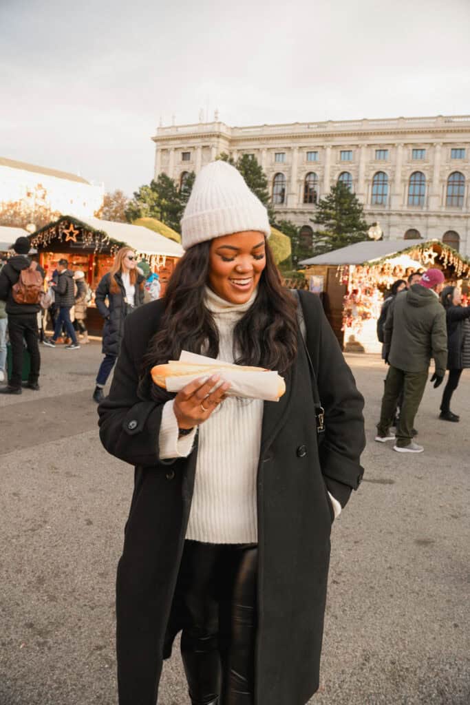 enjoying a sausage at the Christmas VIllage at Maria-Theresien-Platz